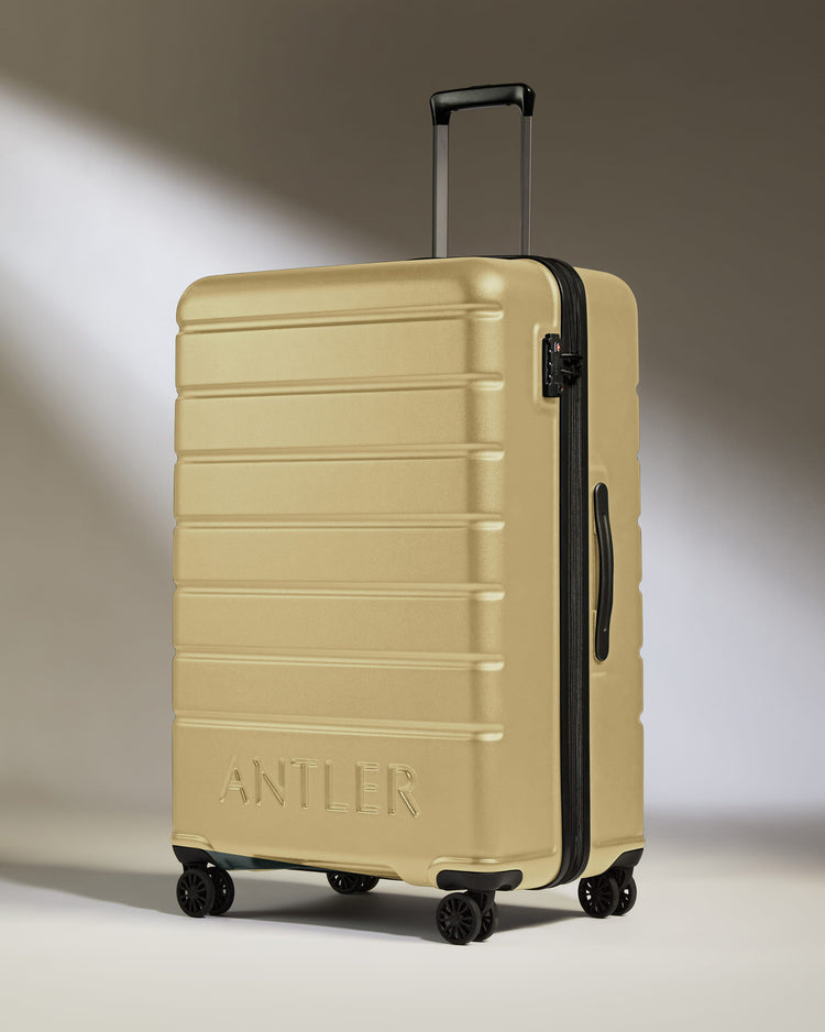 Large Suitcase in Dark Sand - Logo