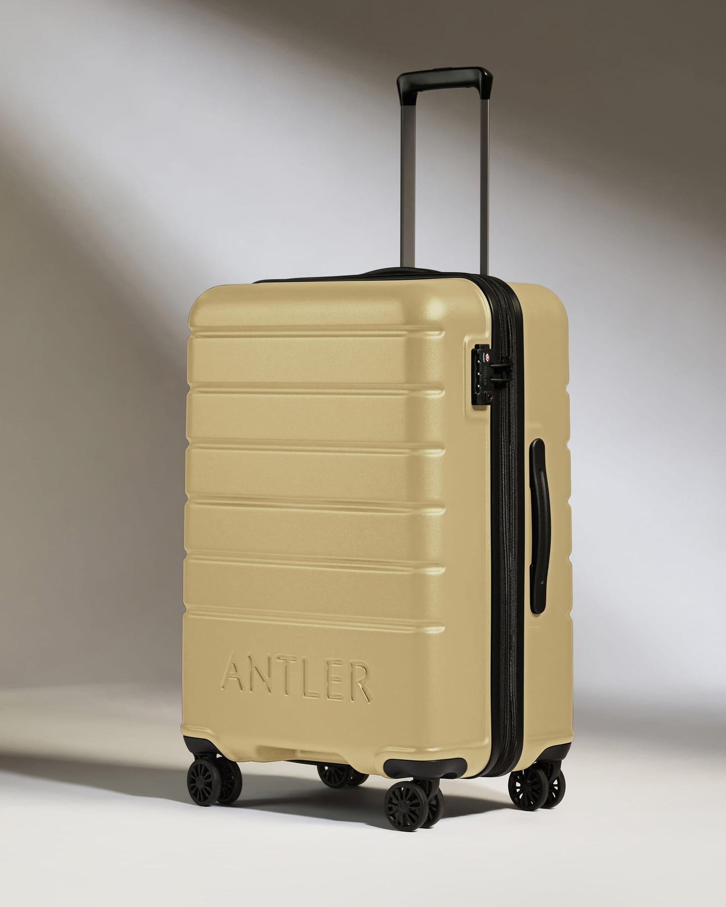 Medium Suitcase in Dark Sand - Logo