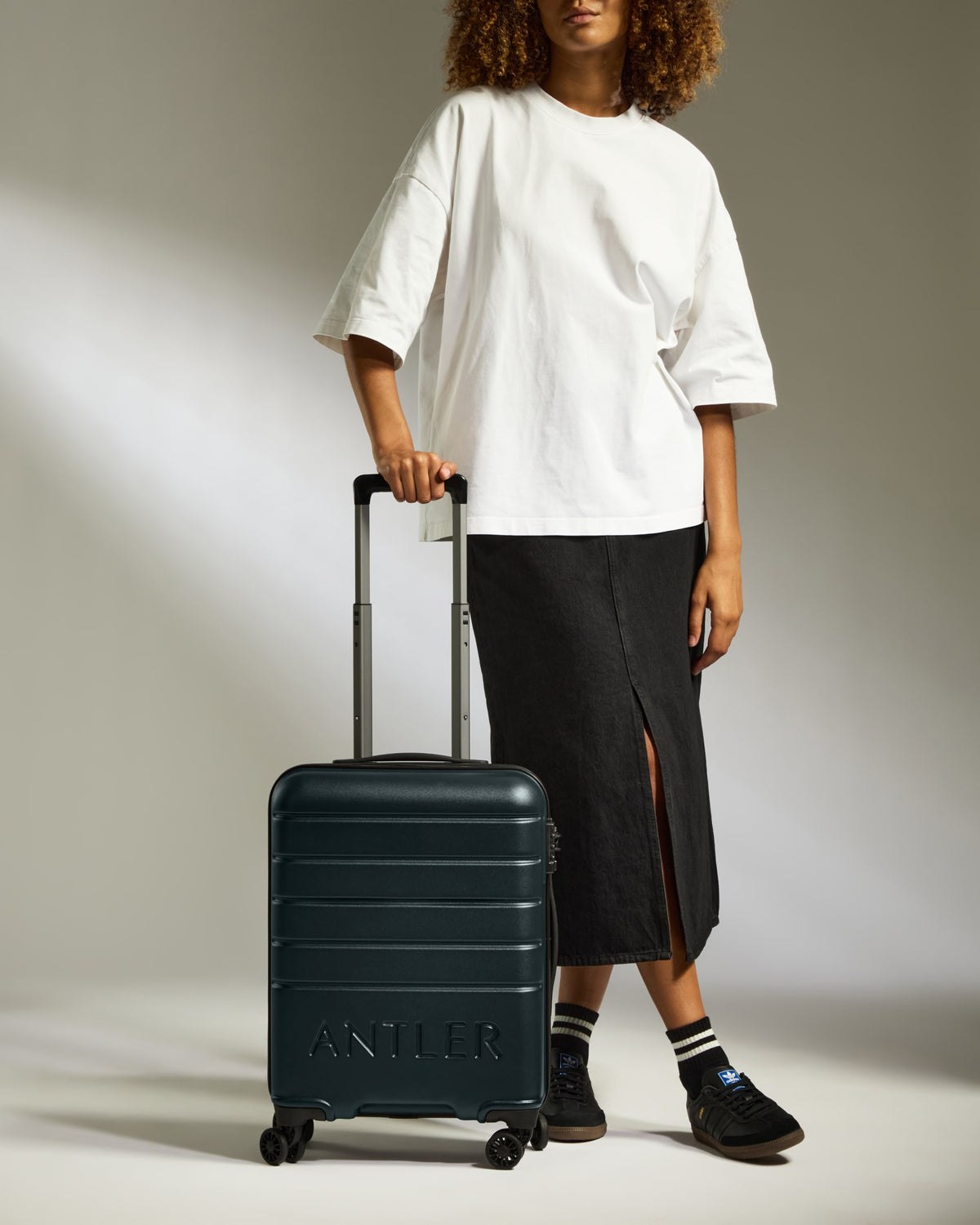 a woman wearing a white shirt and black skirt with a suitcase