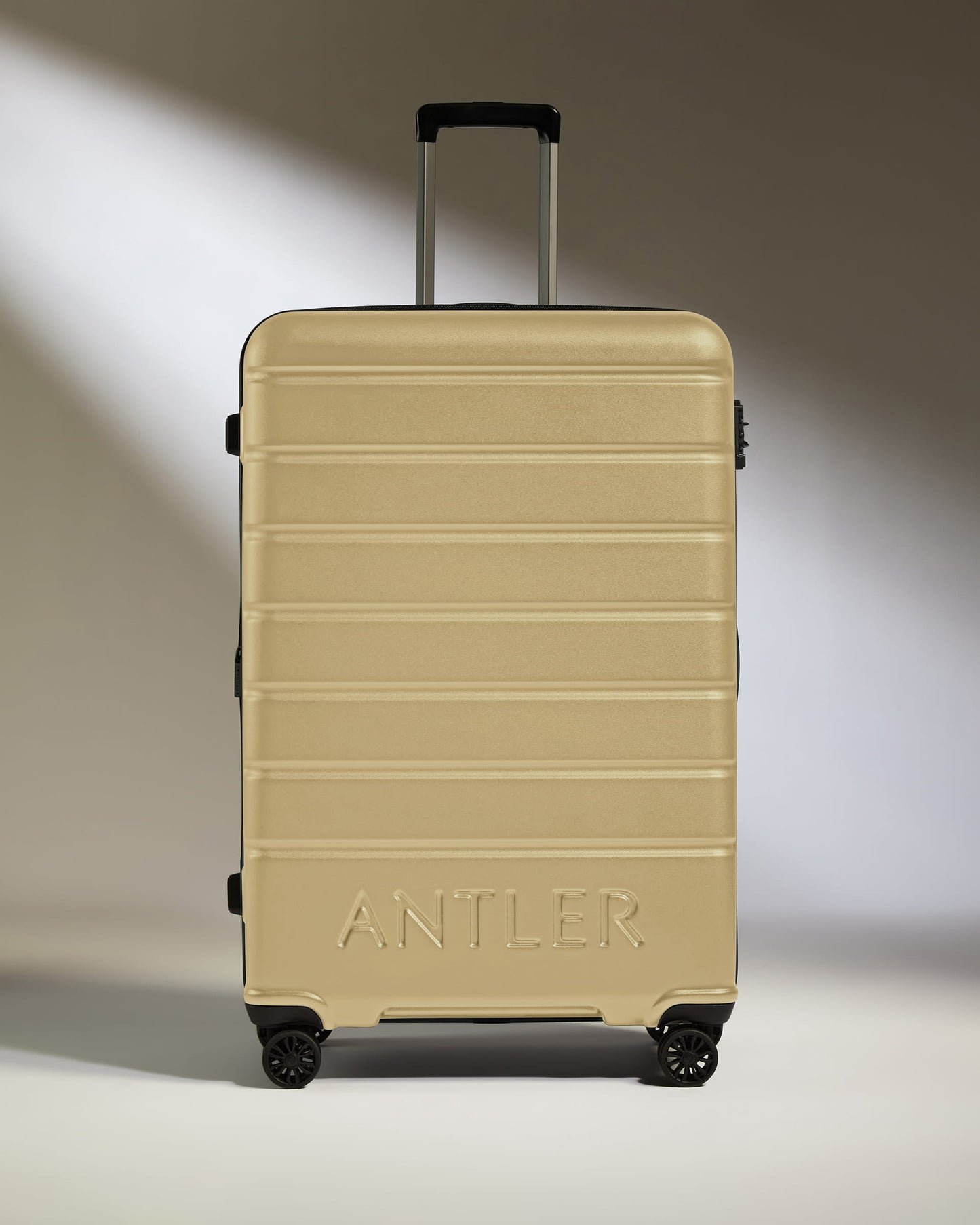 Large Suitcase in Dark Sand - Logo