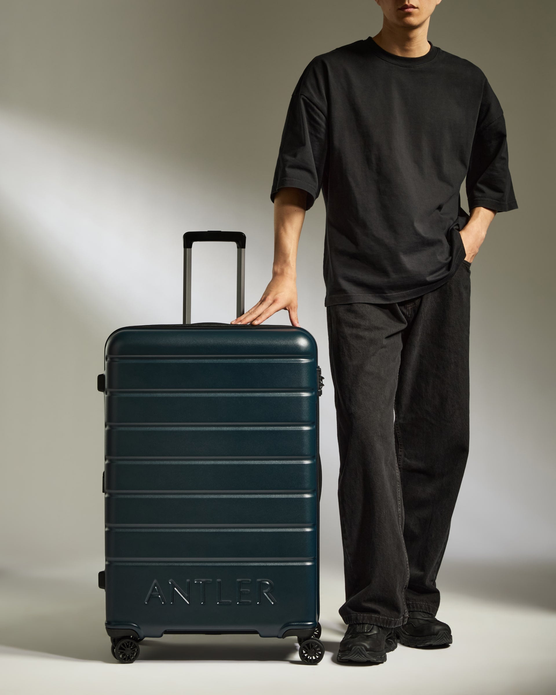 a man standing next to a suitcase