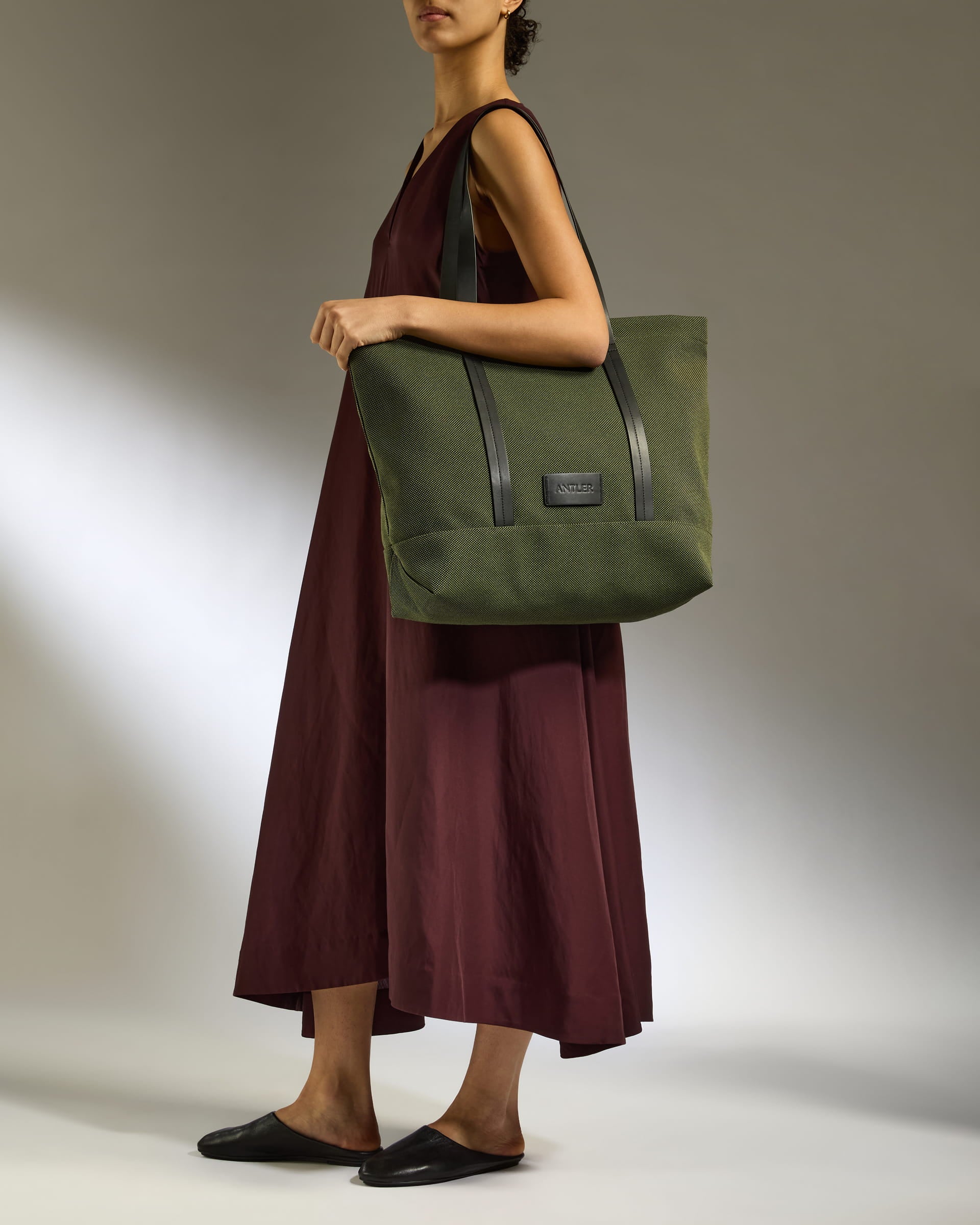 a woman in a dress holding a green bag