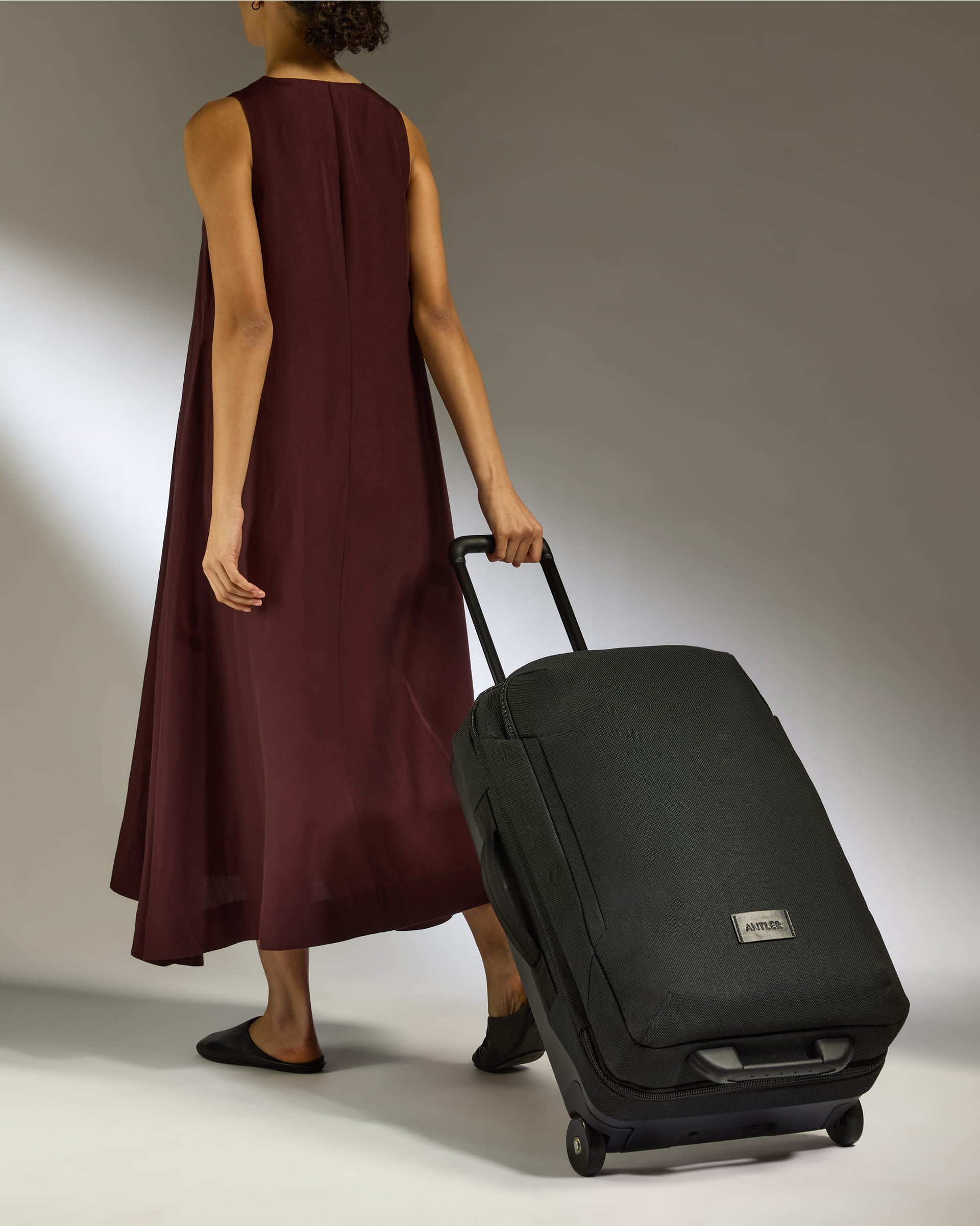 a woman in a long dress and a black suitcase