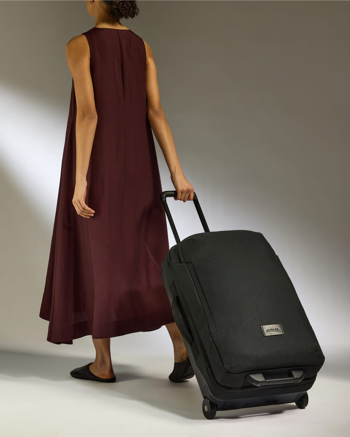 a woman in a long dress and a black suitcase