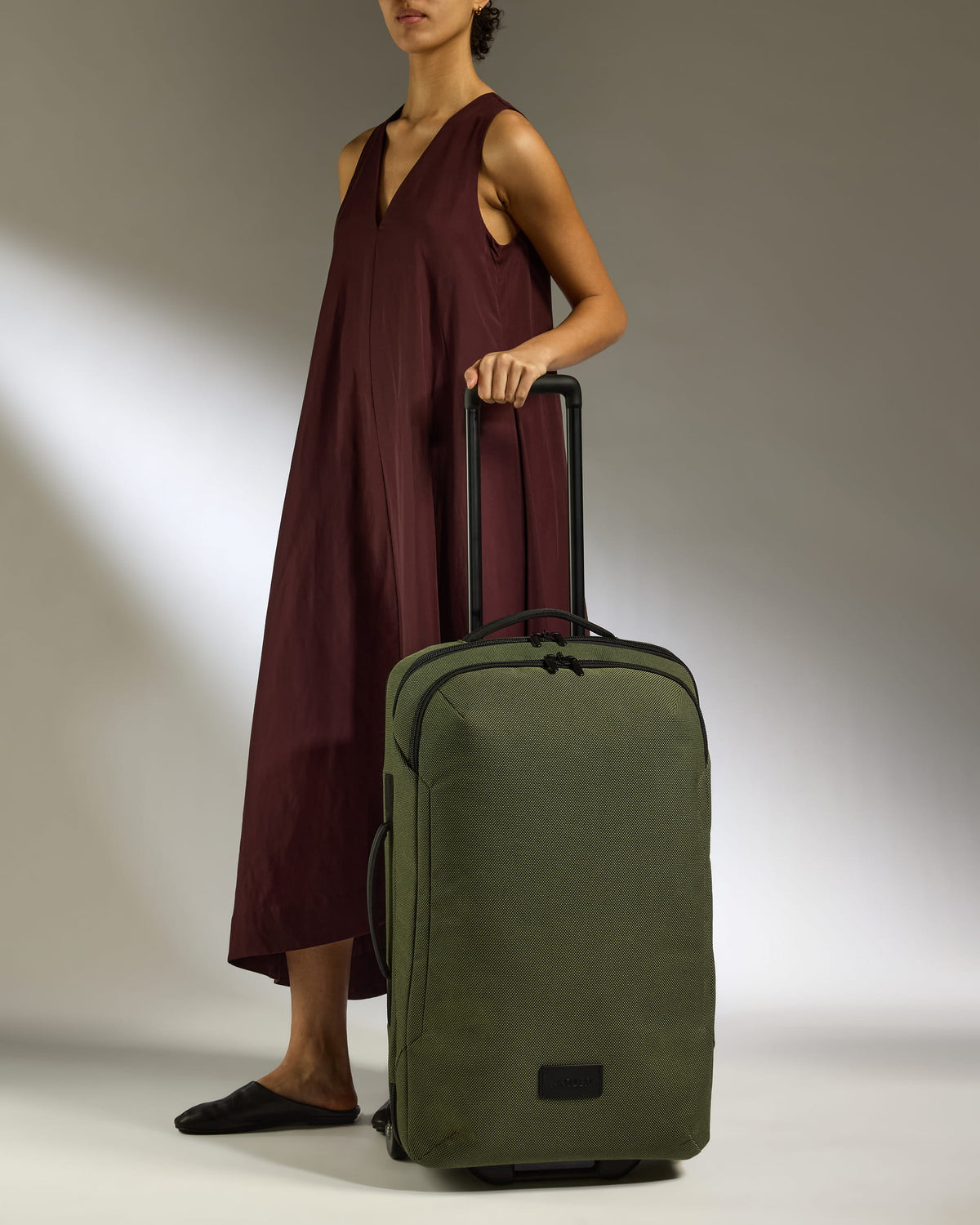 a woman in a dress holding a suitcase