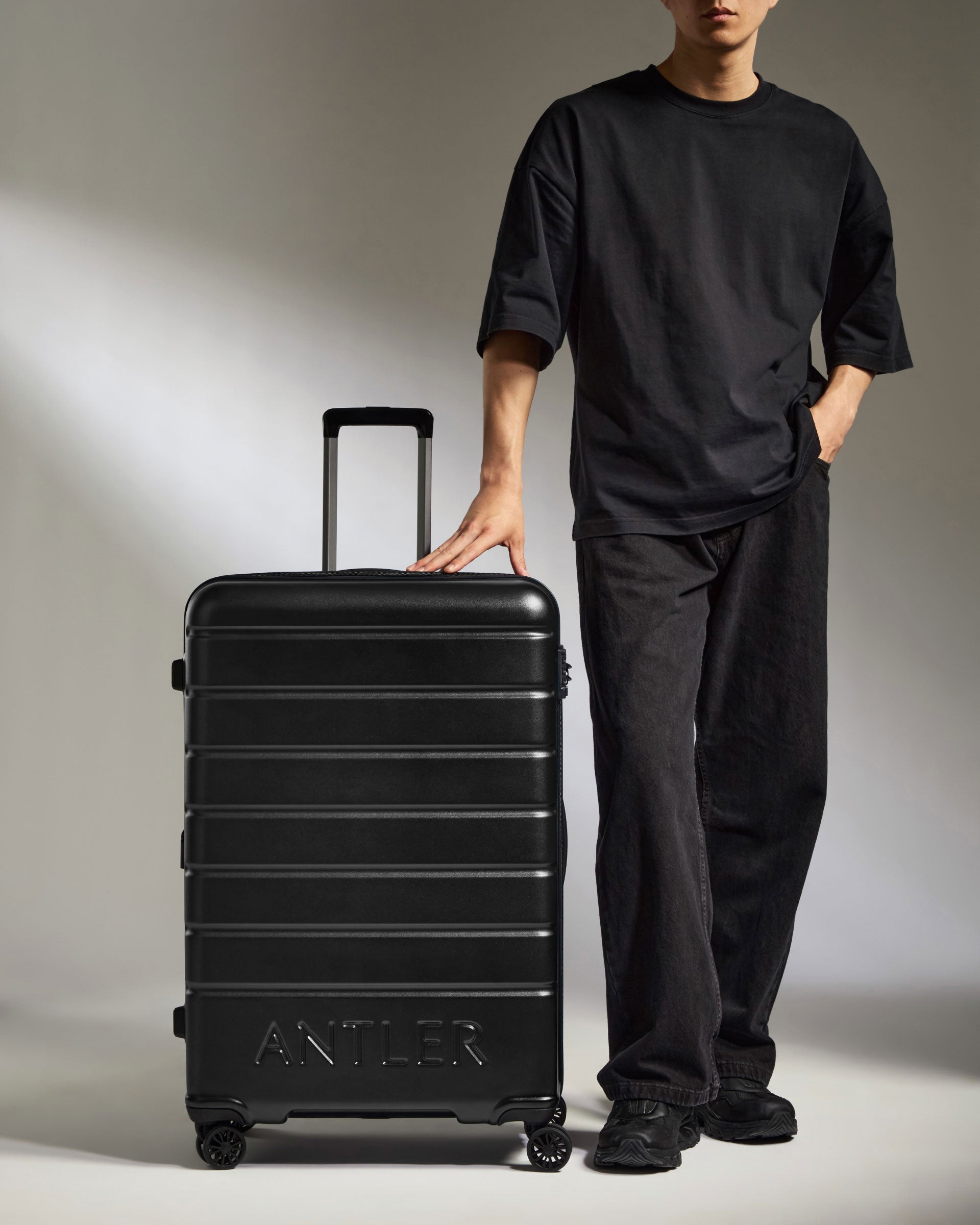 a man standing next to a suitcase