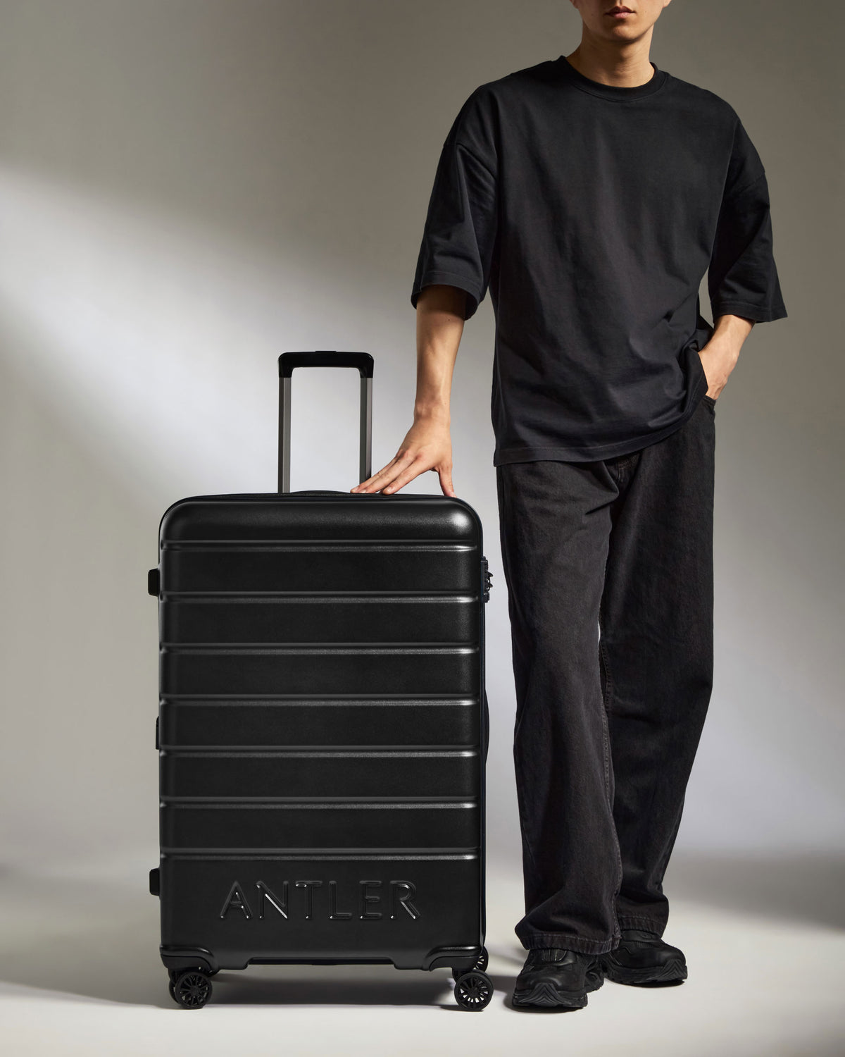a man standing next to a suitcase