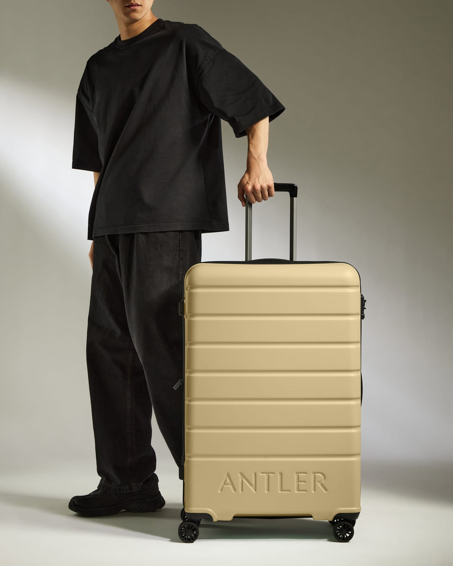Large Suitcase in Dark Sand - Logo