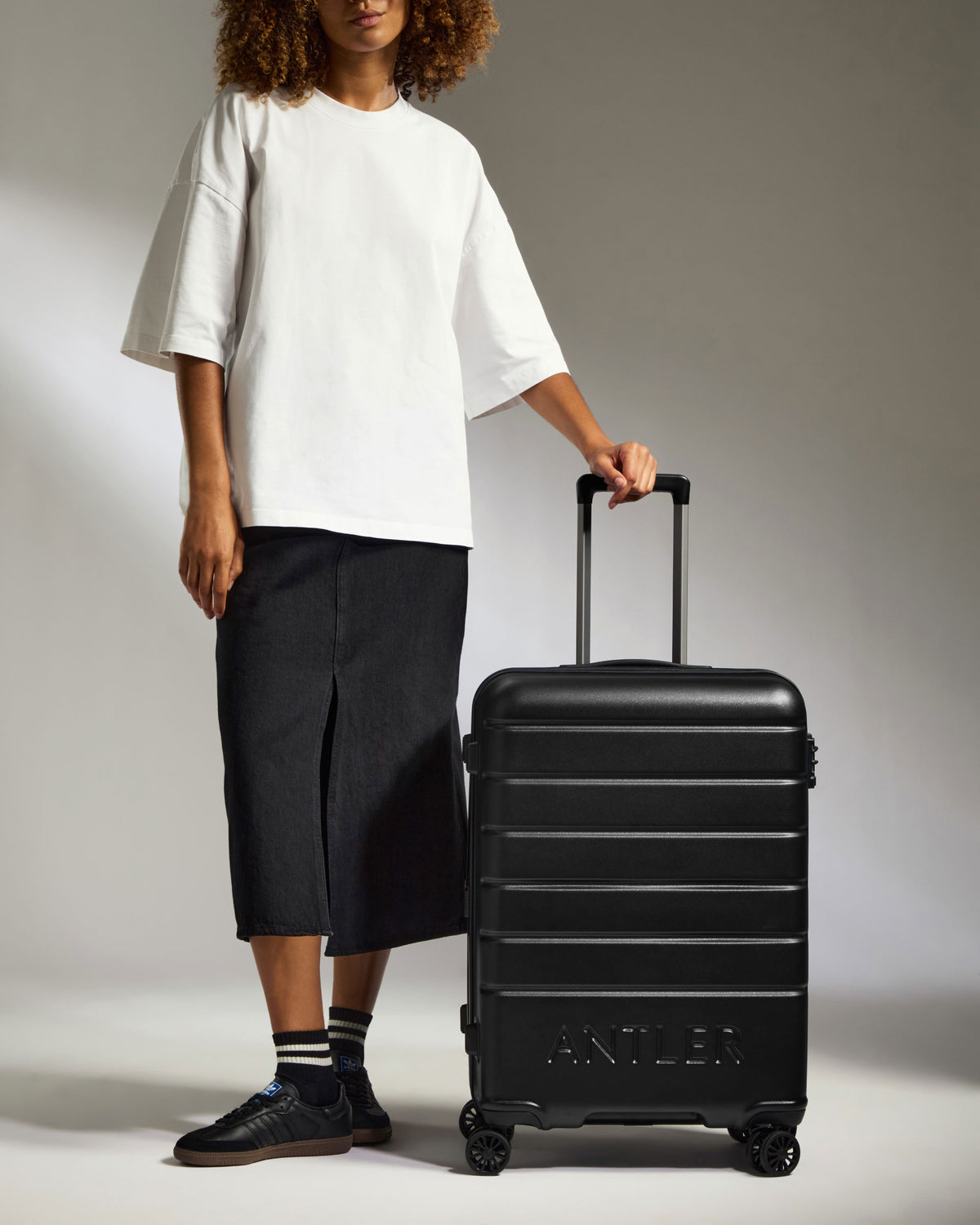 a person standing next to a suitcase
