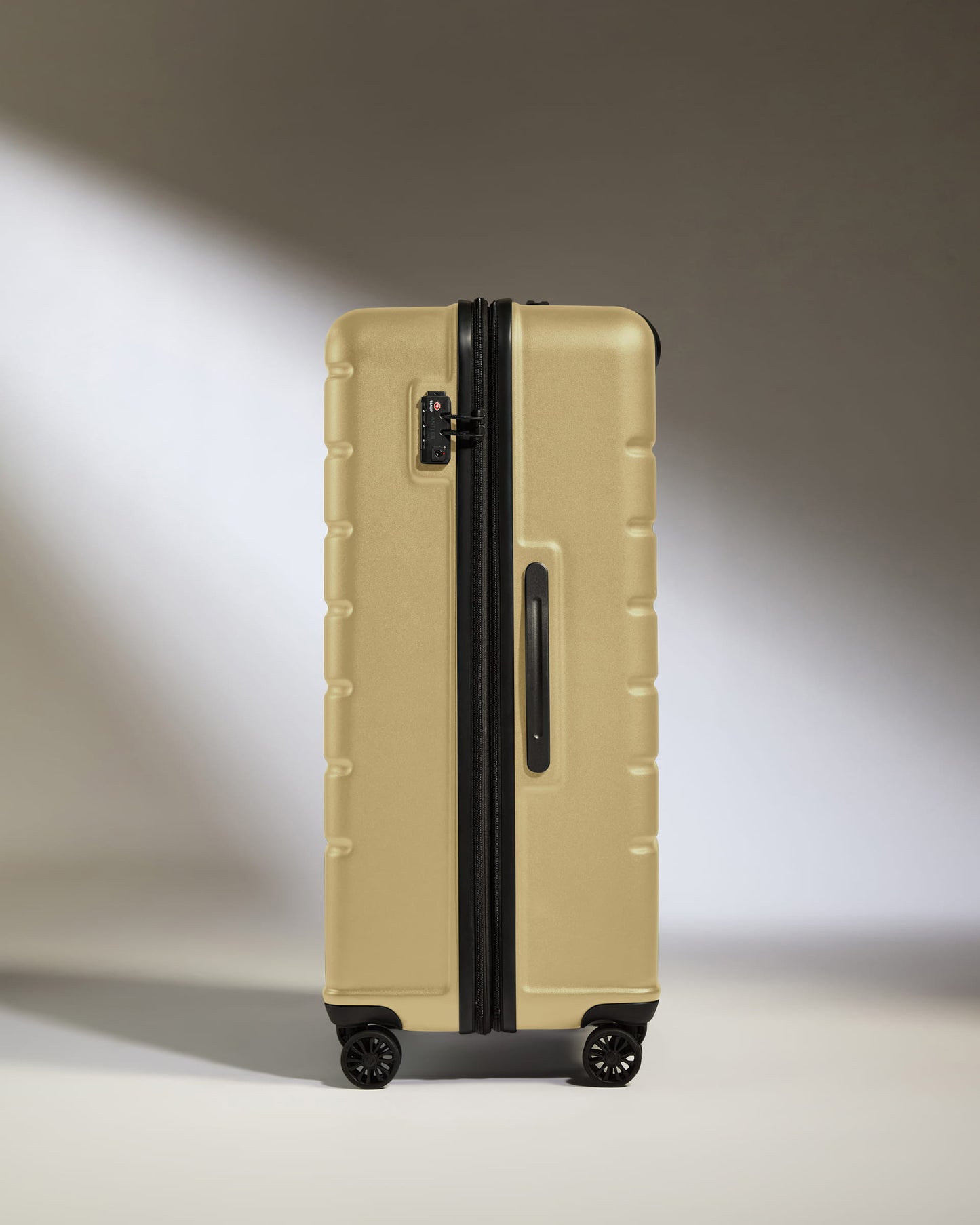 Large Suitcase in Dark Sand - Logo