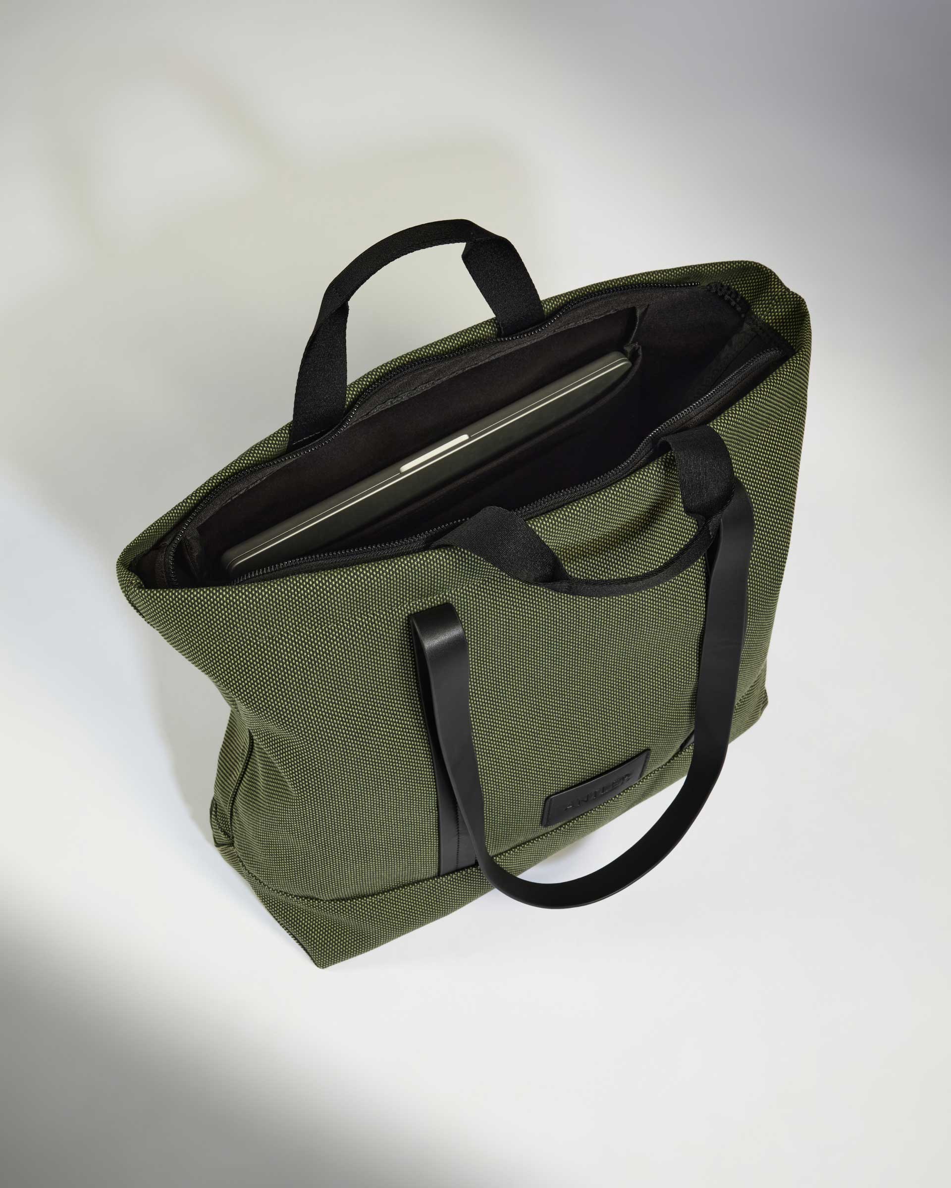 a green bag with a laptop inside