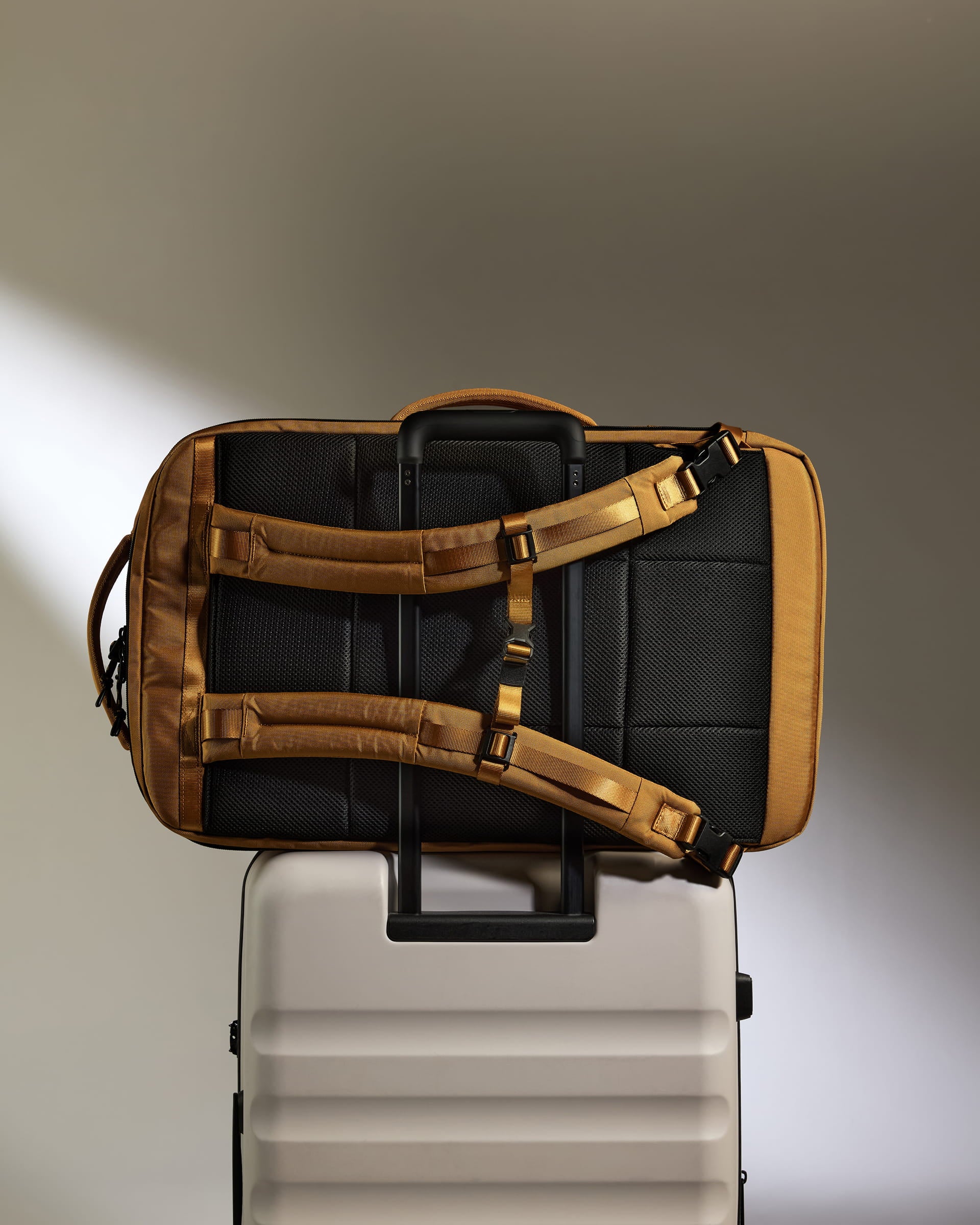 a black and gold bag on top of a white suitcase