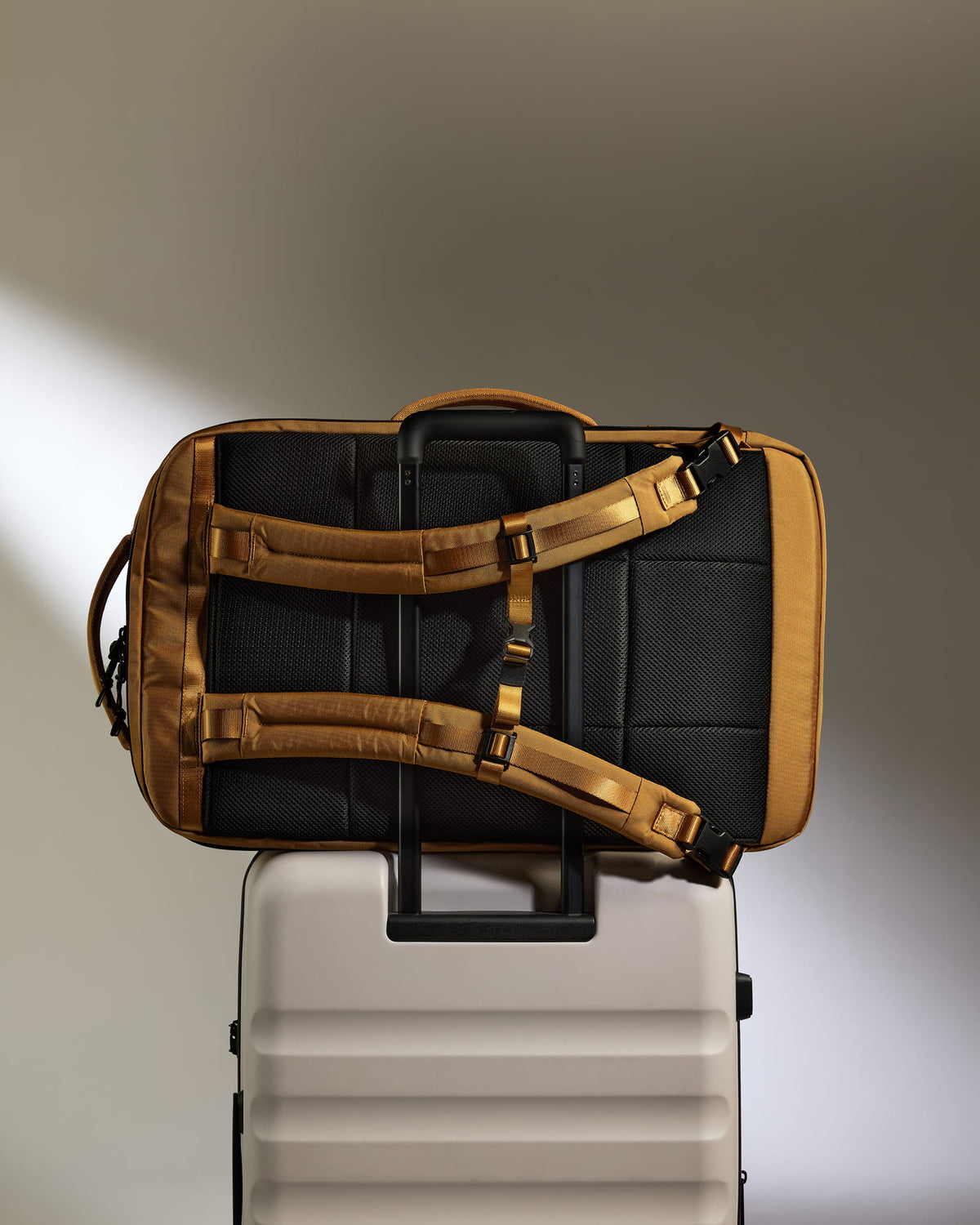 a black and gold bag on top of a white suitcase
