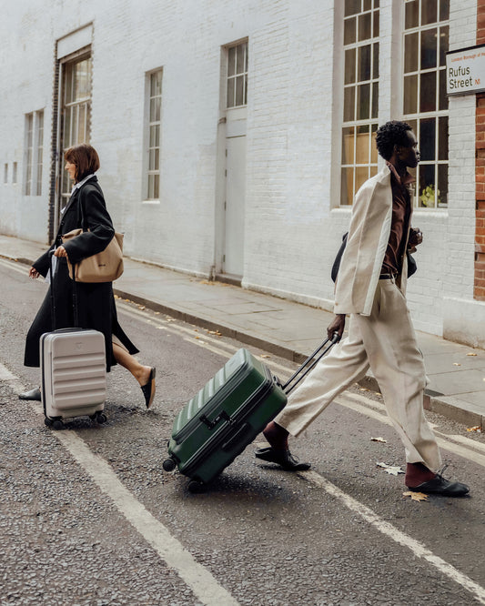 a man and woman walking with luggage