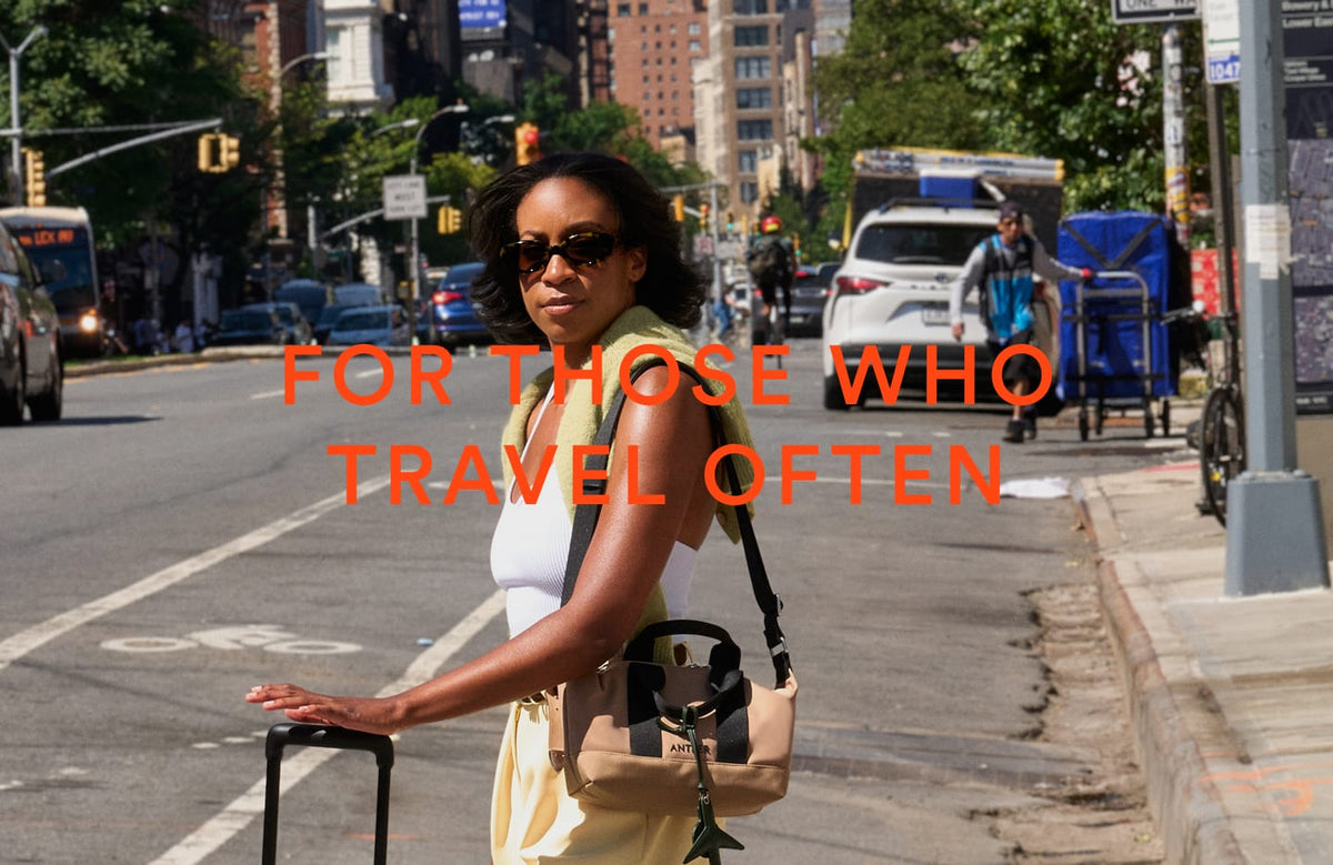a woman with a bag and a suitcase on a street