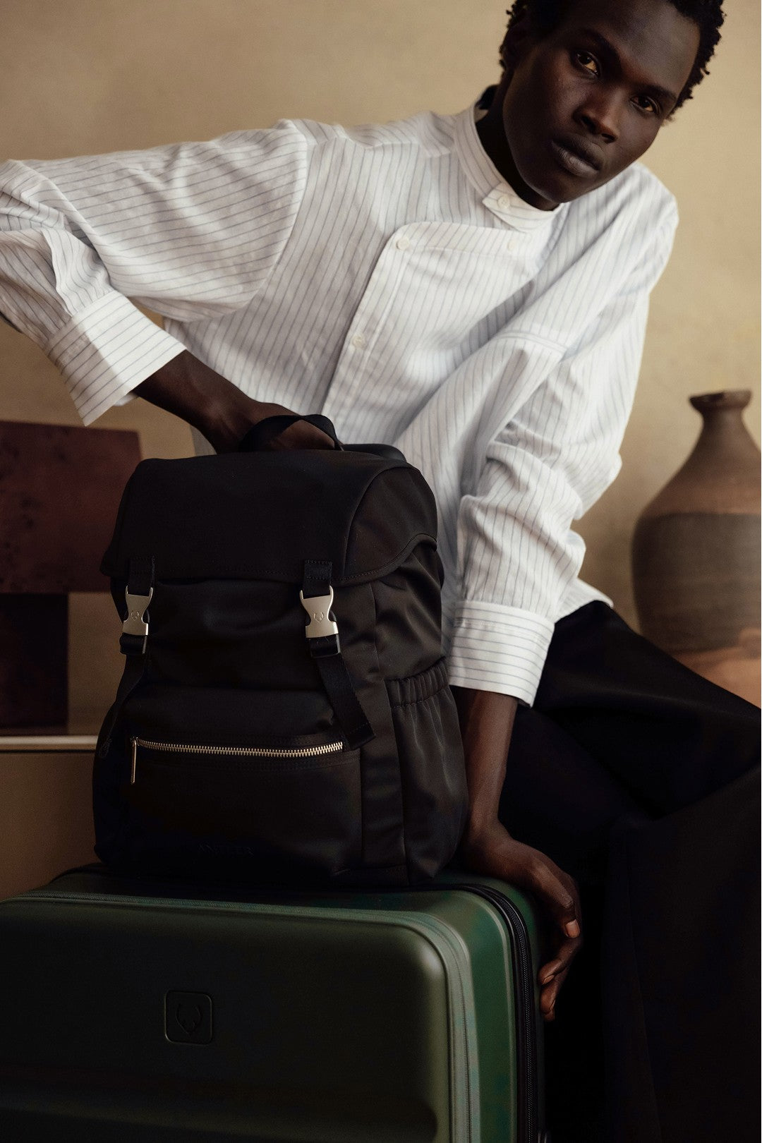 a man in a white shirt and black pants holding a backpack