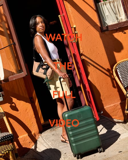 a woman standing in a doorway with a suitcase