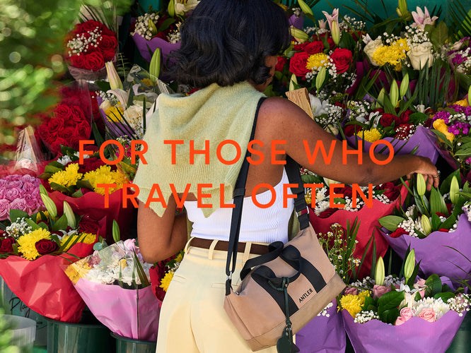 a woman standing in front of a bunch of flowers
