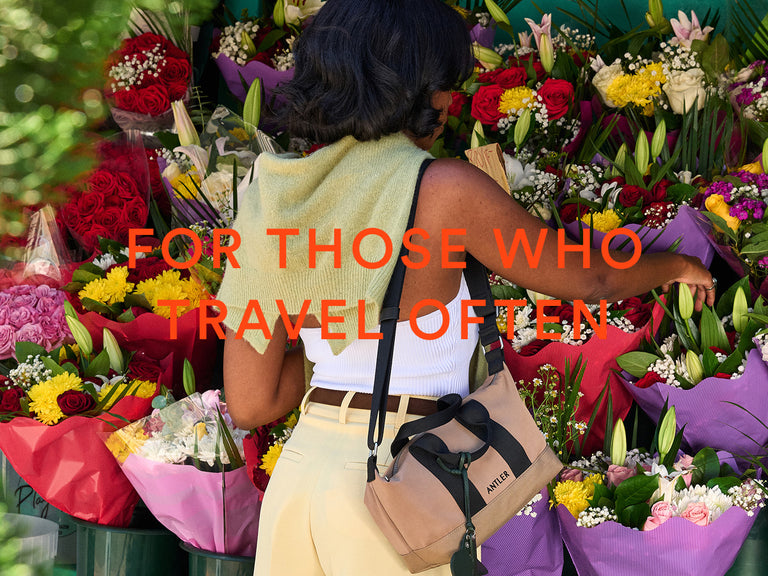 a woman standing in front of a bunch of flowers